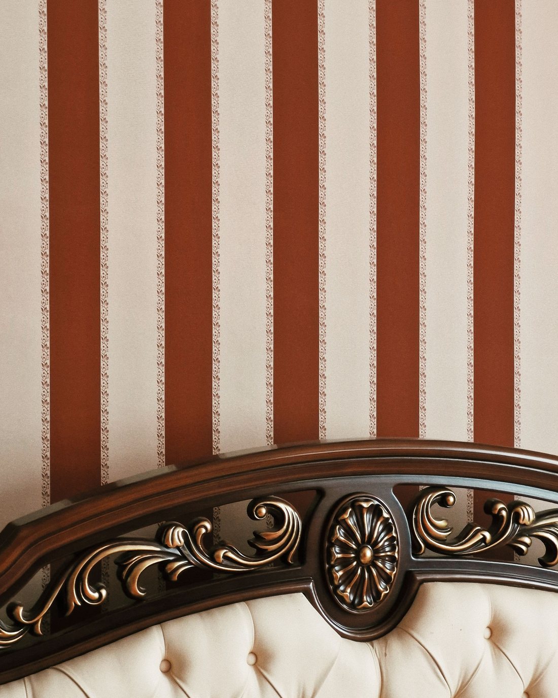 Bedroom with warm terracotta and cream striped wallpaper