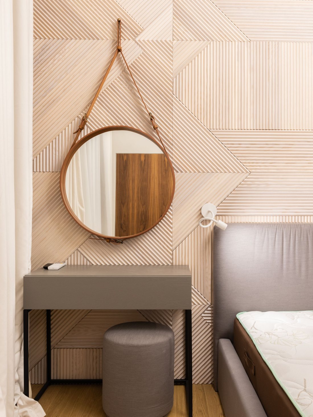 Warm wood-panelled feature wall with a round mirror