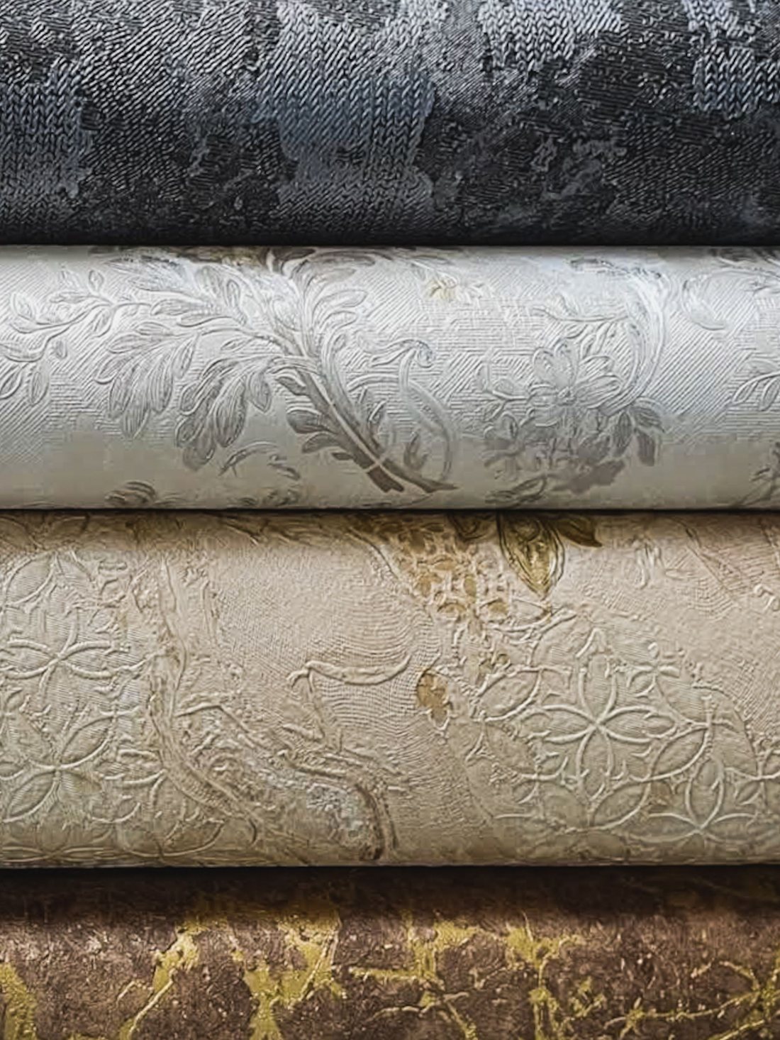 Rolls of patterned wallpaper in warm gold tones