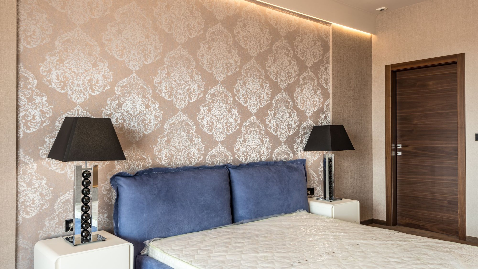 Elegant bedroom with champagne damask wallpaper and warm lighting